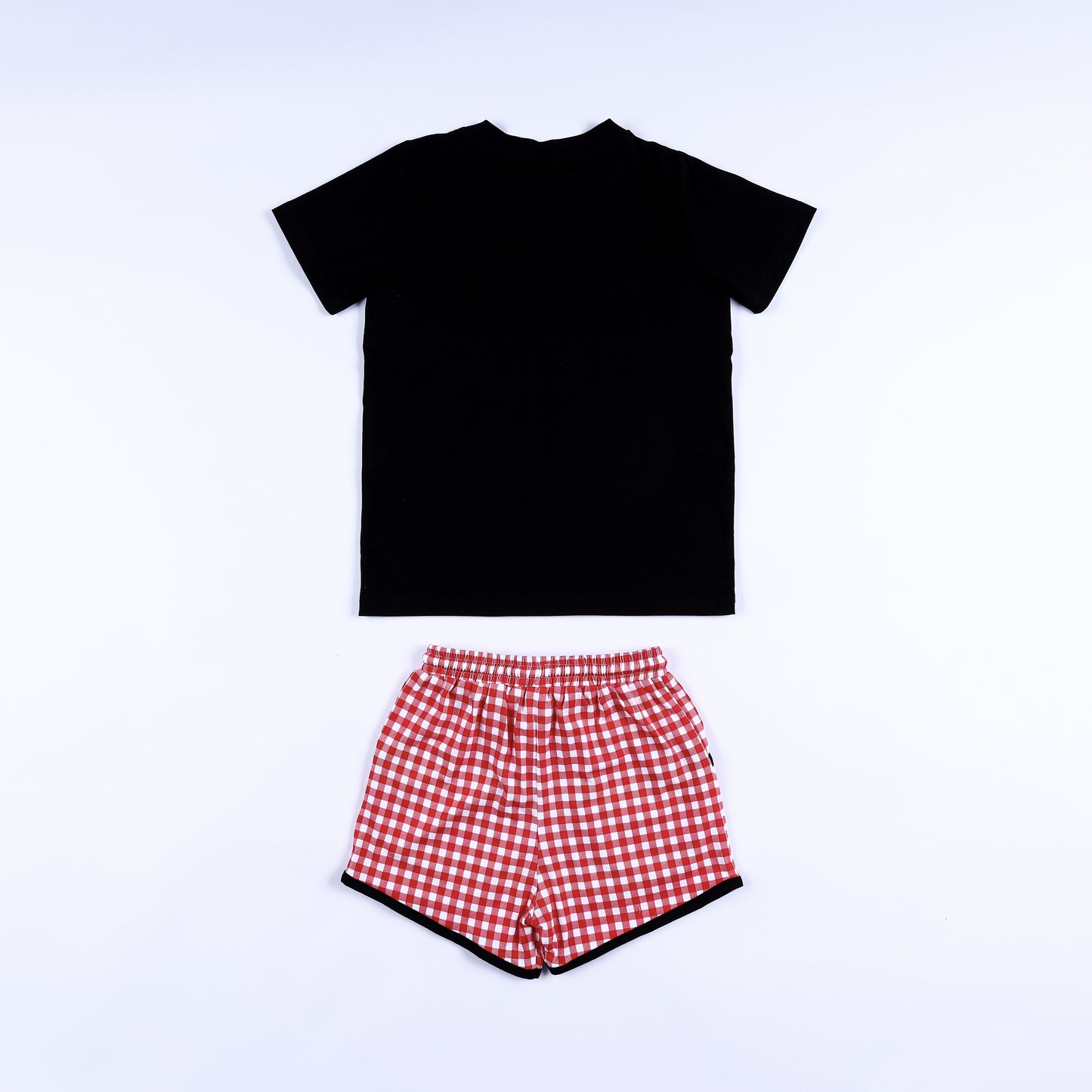 Back view of black short-sleeve shirt and red gingham drawstring shorts for boys smocked clothing set.
