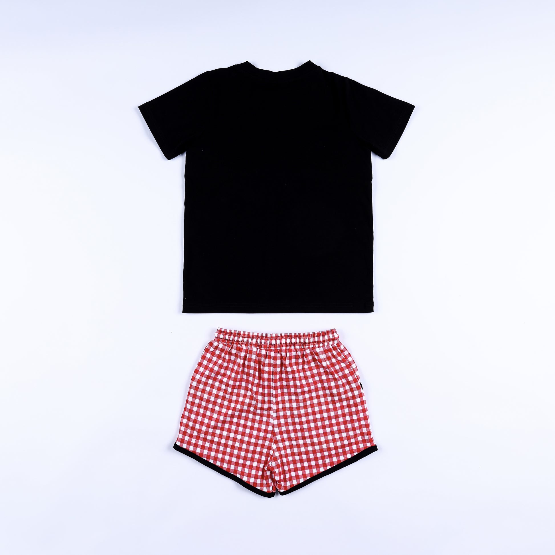 Back view of black short-sleeve shirt and red gingham drawstring shorts for boys smocked clothing set.