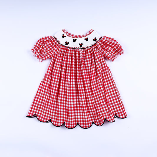 Red gingham mouse hand smocked dress for girls featuring puff sleeves and a scalloped black trimmed hem.