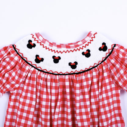 Close up of hand smocked white collar featuring hand embroidered black mouse heads with red bows on red gingham.