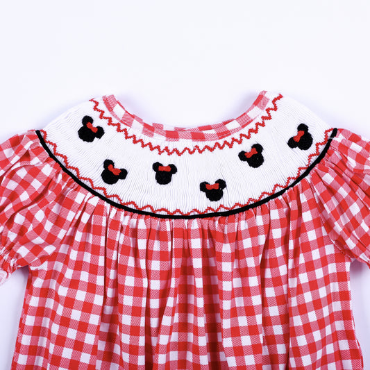 Close up of hand smocked white collar featuring hand embroidered black mouse heads with red bows on red gingham.
