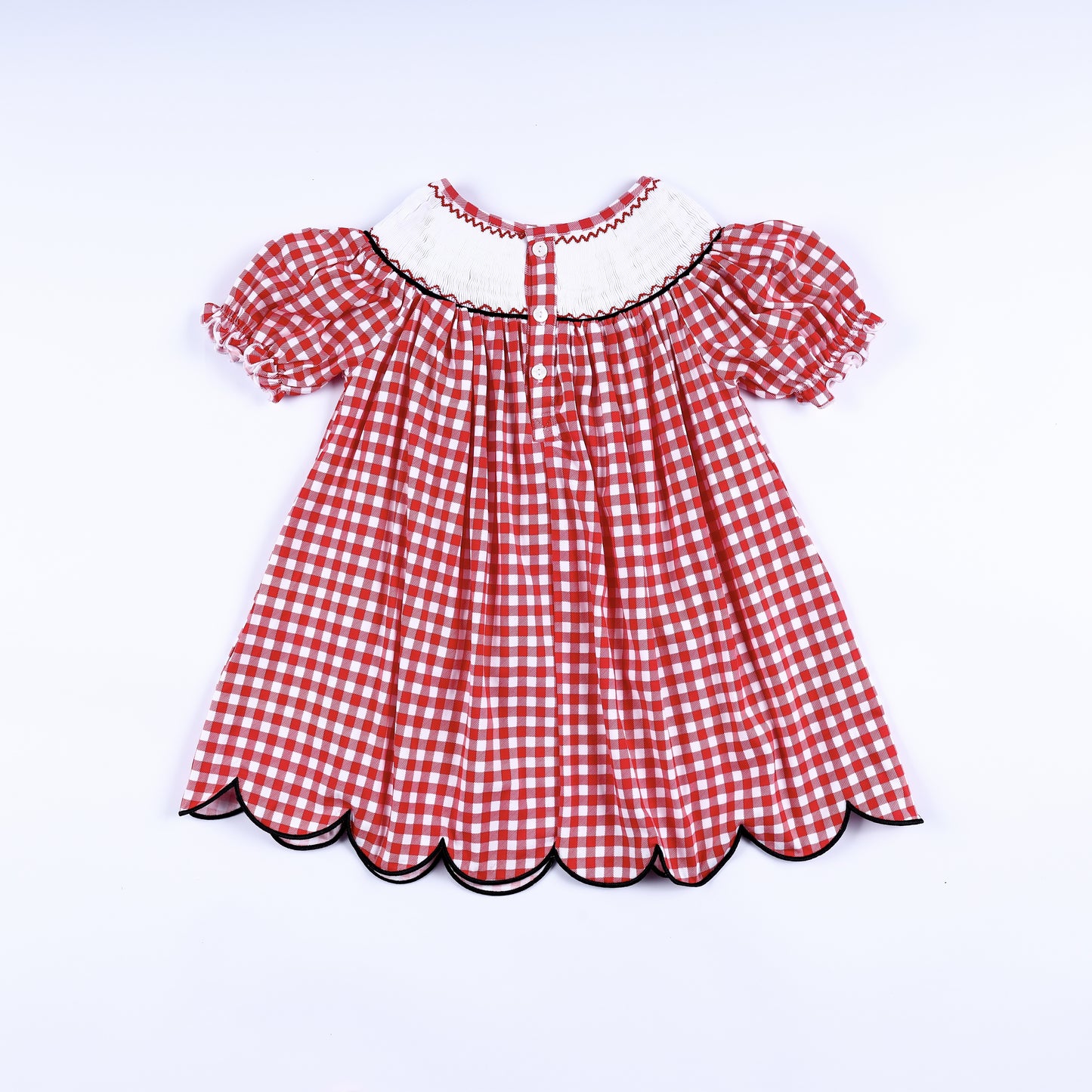 Full back view of the red gingham hand smocked mouse dress showing the button closure and scalloped hem.