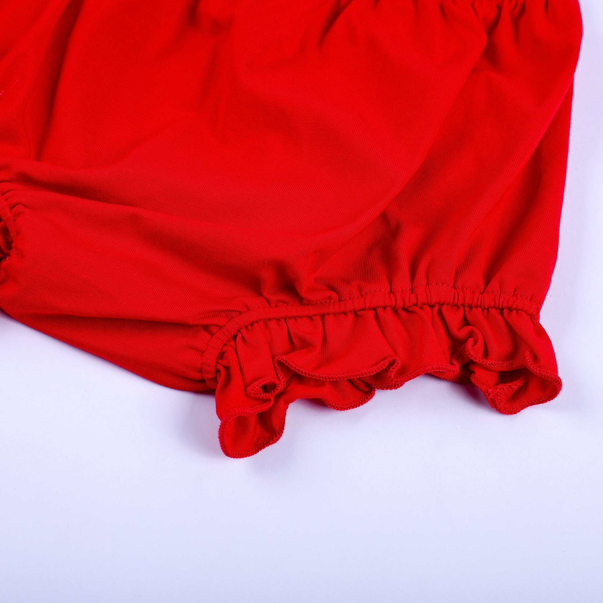 Detailed close up of the soft red ruffled leg hem on a baby girl bloomer diaper cover matching set for 4th of July.