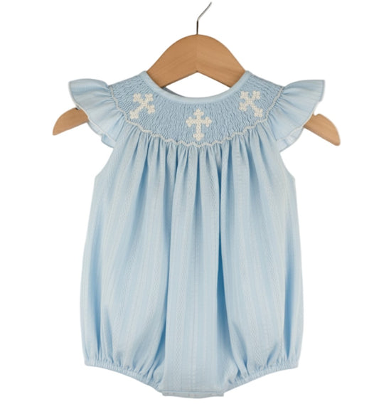 Sky blue hand-smocked baby bubble romper with flutter sleeves and white cross embroidery for christenings.