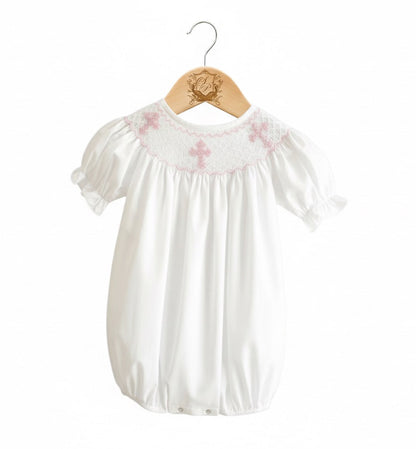 White baby bubble with pink hand smocking and embroidered crosses, featuring 360-degree embroidery.