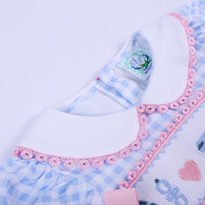 Angled close-up of the white Peter Pan collar with delicate pink lace trim on the blue gingham baby shower romper.