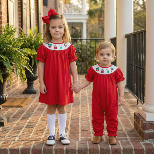 Smocked Girls Christmas Magical Character Treats Red Dress and matching sibling romper on two girls holding hands.