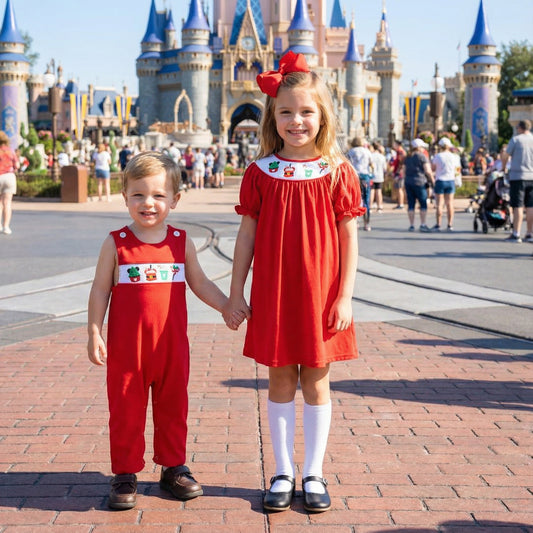 Matching siblings wearing Smocked Boys Christmas Magical Character Treats Jon Jon and sister in matching smocked dress.
