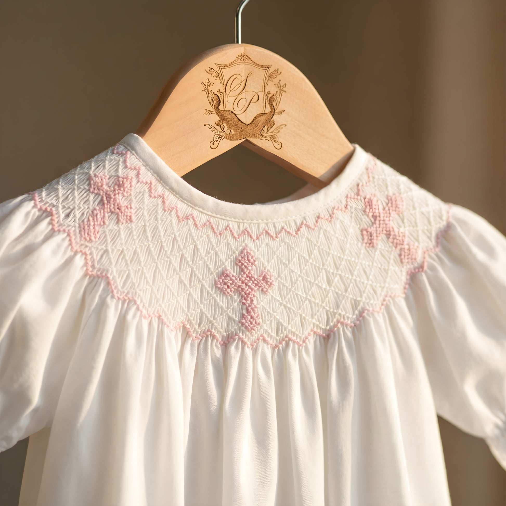 White Sunday Best Girl Bubble featuring a Hand Smocked neckline with Pink Hand Embroidered Crosses.