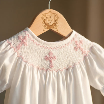 White Sunday Best Girl Bubble featuring a Hand Smocked neckline with Pink Hand Embroidered Crosses.