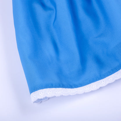 Close-up view of delicate white eyelet lace trimming along the bottom hem of blue smocked girls dress.