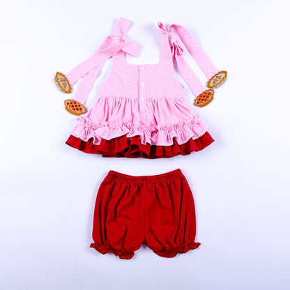 Back view of girls pink polka dot top with red bloomer shorts showing button closure and strap bows.
