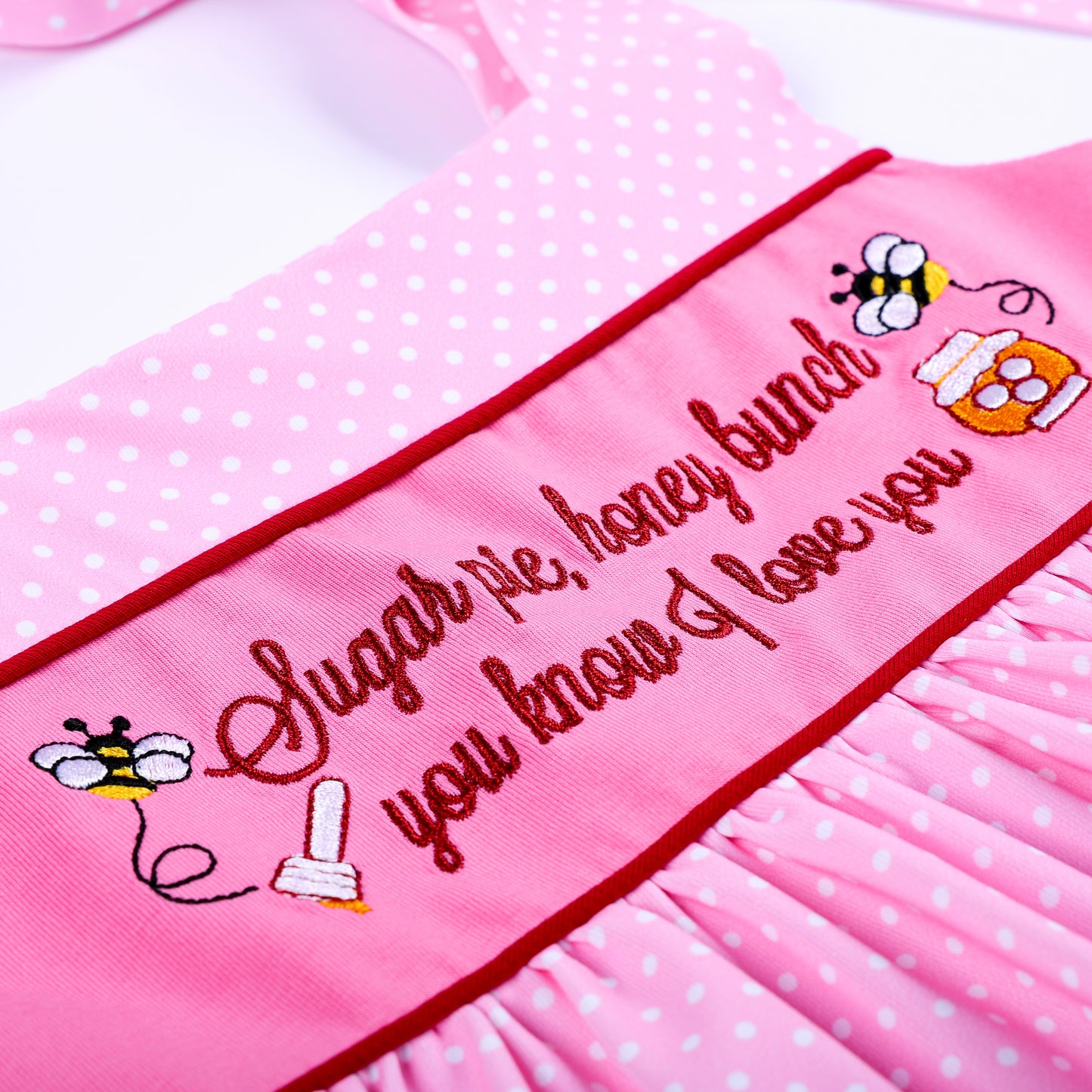 Close-up view of Sugar Pie Honey Bunch embroidery with cute honey pot and bee details on pink top.
