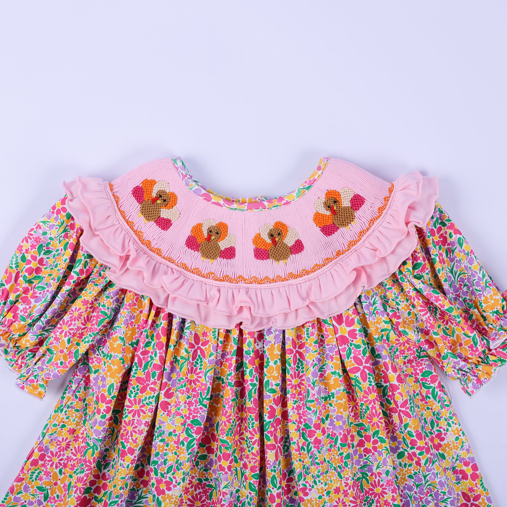 Close-up of the hand-smocked pink collar with embroidered turkeys on the Thanksgiving floral boutique tunic top.