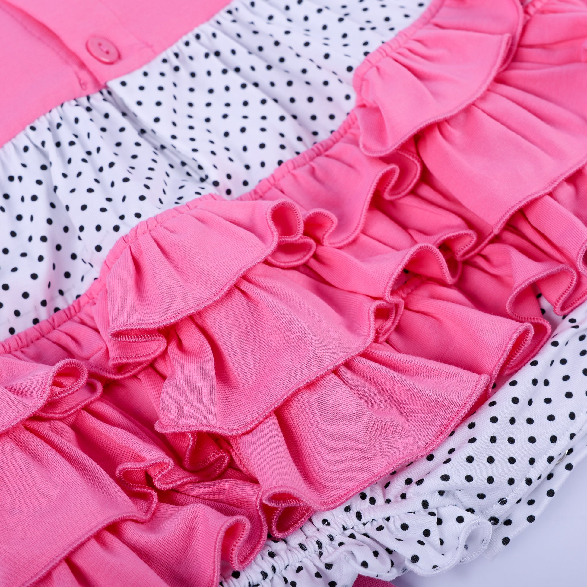 Detailed back view of pink layered ruffles and polka dot bloomers on hand-smocked baby girl fashion bubble romper.