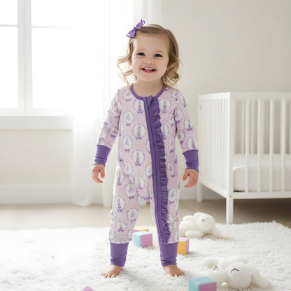 Happy toddler girl standing in a modern nursery wearing the purple Nutcracker ballet ruffle girls zippy romper.