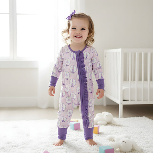 Happy toddler girl standing in a modern nursery wearing the purple Nutcracker ballet ruffle girls zippy romper.