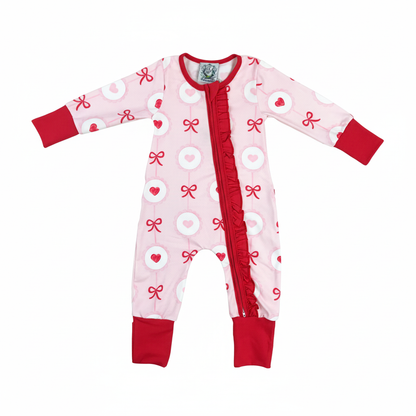 Front view of pink Valentine's Day heart and bow girl zippy romper featuring a full-length red ruffled zipper.