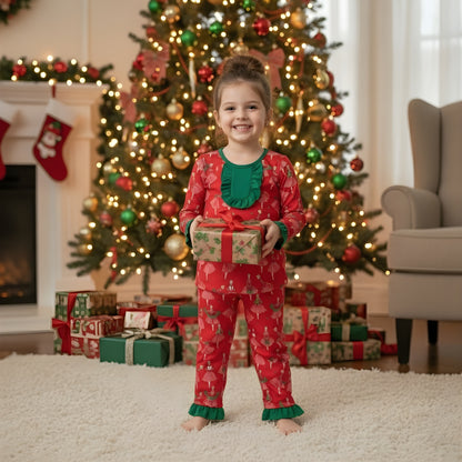 Little girl holding a wrapped present wearing vintage Christmas lady icons red pajama set with green trim.